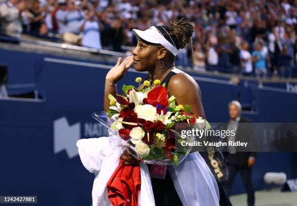 Serena Williams of the United States wavess to the crowd as she leaves the court after losing to Belinda Bencic of Switzerland during the National...