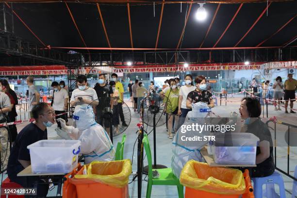 This photo taken on August 10, 2022 shows residents undergoing nucleic acid tests for the Covid-19 coronavirus at a swab collection site in Xiamen,...