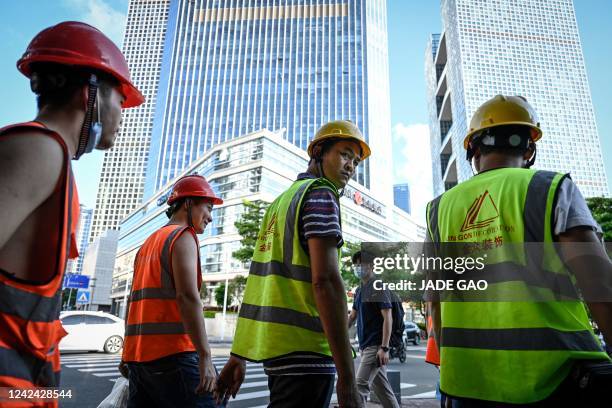 This photo taken on July 20 shows construction workers crossing a road in Shenzhen, in China's southern Guangdong province.