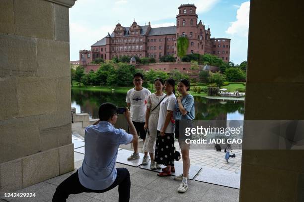 This photo taken on July 9 shows Huawei employees and their families taking photos at the Huawei European-themed campus in Dongguan, in China's...