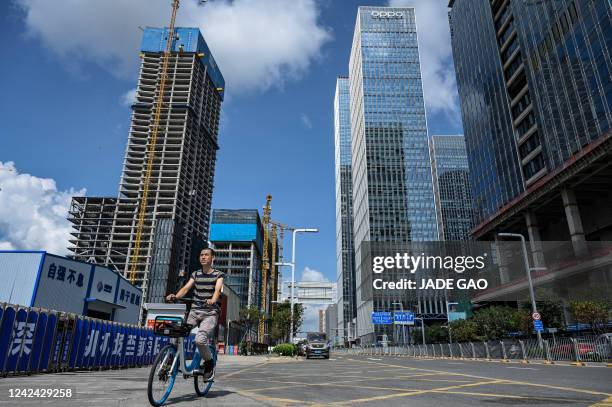 This photo taken on July 20, 2022 shows a man riding a bicycle along a street in Shenzhen, China's southern Guangdong province.