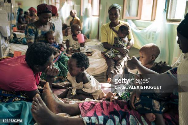 War-displaced women feed and play with their children at Rutshuru Hospital in the eastern province of North Kivu, Democratic Republic of Congo, on...
