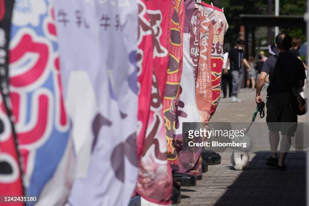 Man walks a dog at the Dangozaka service area on the Chuo Expressway in Uenohara, Yamanashi Prefecture, Japan, on Thursday, Aug. 11, 2022. The Obon...