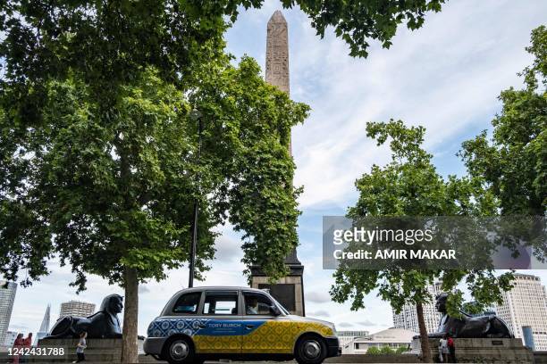 Taxi cab drives past the ancient Egyptian Obelisk of Thutmose III , known as "Cleopatra's Needle", along the Thames river embankment in London on...