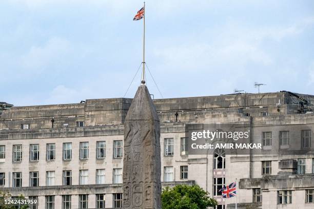 The British unionjack flag flies atop a building behind the ancient Egyptian Obelisk of Thutmose III , known as Cleopatra's Needle", along the Thames...