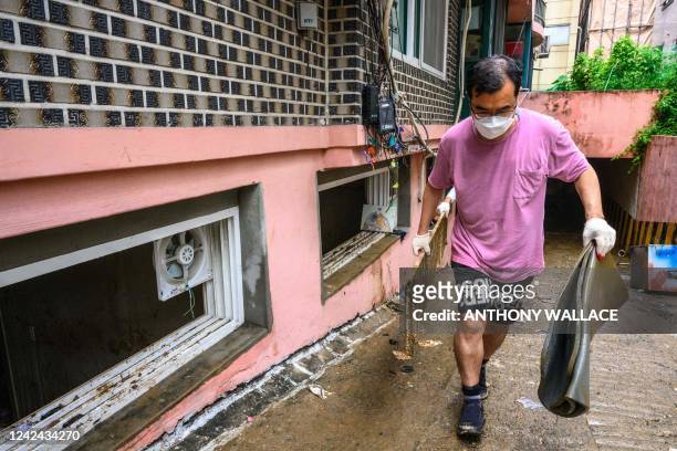 Man helps to clear debris from a basement flat known as "banjiha" in the Gwanak district of Seoul on August 11 after flooding caused by...