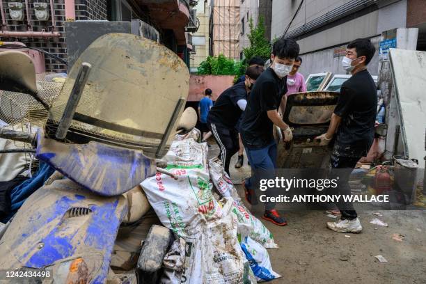 People clear debris from a basement flat known as "banjiha" in the Gwanak district of Seoul on August 11 after flooding caused by record-breaking...