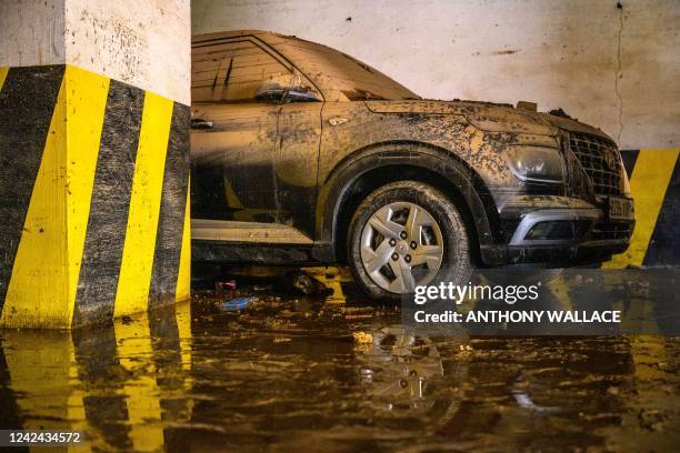 Mud-caked car is seen in a basement parking lot in the same building where three tenants of a basement flat known as "banjiha", including a disabled...