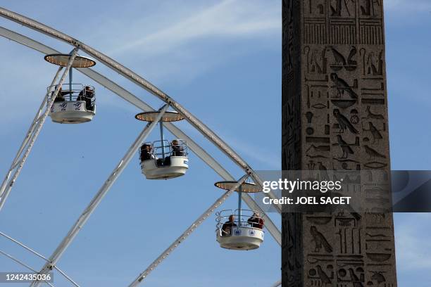 Vue prise le 20 septembre 2007 sur la place de la Concorde à Paris des hiéroglyphes de l'Obélisque avec en fond des passagers de la grande roue en...