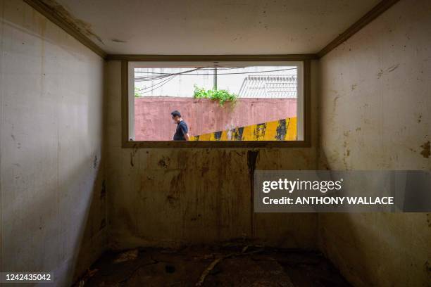 Man walks outside a basement flat known as "banjiha" which has markings left by mud brought by floodwaters in the Gwanak district of Seoul on August...