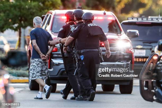 Arcadia, CA, Wednesday, August 10, 2022 - A man is detained and led away from the scene as an active shooter remains barricaded in a home on...