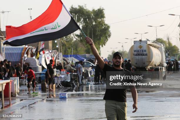 Protester wields an Iraqi flag during protests by followers of Shiite cleric Moqtada al-Sadr in Baghdad, Iraq on Aug. 8, 2022. Amid a protracted...