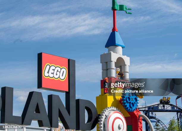 August 2022, Bavaria, Günzburg: A roller coaster can be seen next to the logo at the entrance to Legoland. At least 34 people were injured in the...