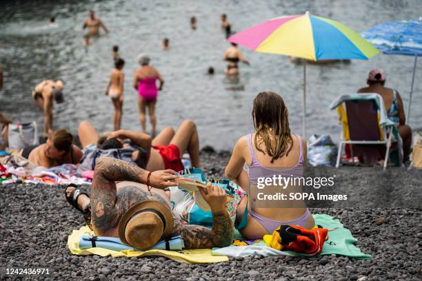 People are relaxing at Playa del Muelle beach in Puerto de la Cruz, Tenerife. Tenerife's main hotspots, in the Canary Islands, fill up with tourists...