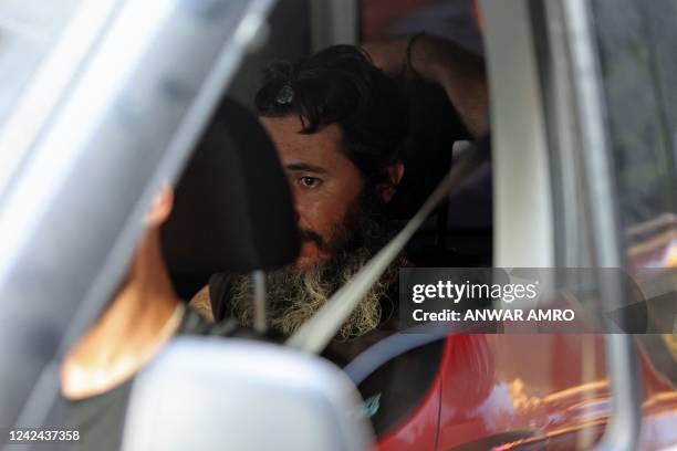 Lebanese armed bank customer is pictured in a police vehicle in Lebanon's capital Beirut on August 11, 2022. - An armed bank customer turned himself...