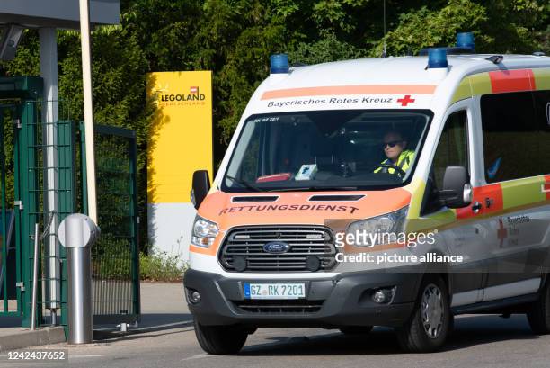 August 2022, Bavaria, Günzburg: An ambulance drives past the entrance to Legoland Germany. 31 people were injured in an accident on a roller coaster...
