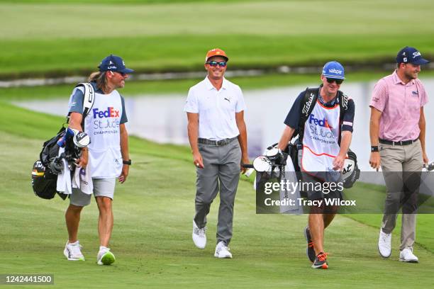 Rickie Fowler walks up the 18th hole with his fill-in caddie, Ben Schomin, Lee Hodges and his caddie, Andrew Medley, during the first round of the...