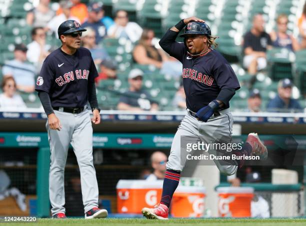 Jose Ramirez of the Cleveland Guardians runs past third base coach Mike Sarbaugh to score and break a 3-3 tie against the Detroit Tigers during the...