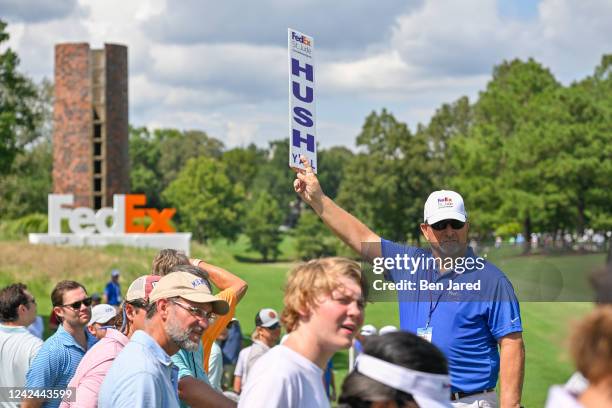 Volunteer holds his hush sign during the first round of the FedEx St. Jude Championship at TPC Southwind on August 11, 2022 in Memphis, Tennessee.