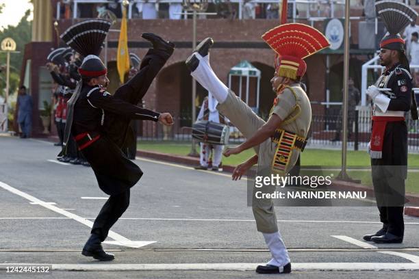In this photograph taken on August 1 an Indian Border Security Force soldier and a Pakistani Ranger perform during the Beating the Retreat ceremony...