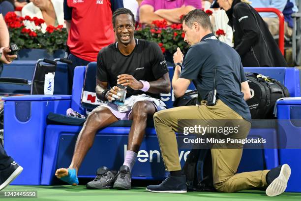 Medical staff tend to Gael Monfils of France after suffering an injuring in his match against Jack Draper of Great Britain during Day 6 of the...