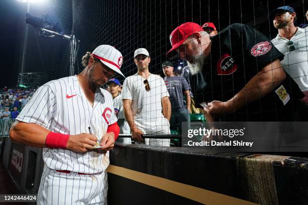 Kyle Farmer of the Cincinnati Reds signs a baseball card for a fan after the game between the Chicago Cubs and the Cincinnati Reds at The MLB Field...