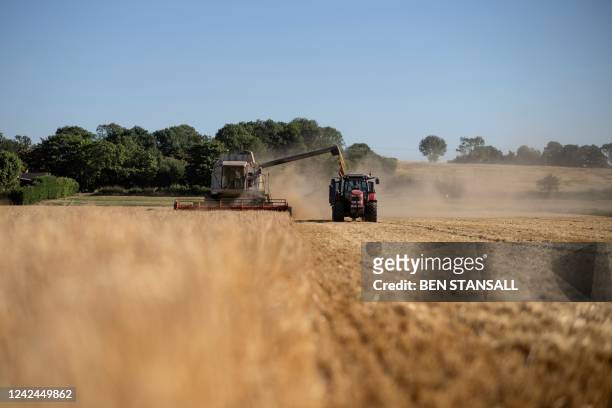 Combine harvest collects spring barley in a field near the village of Washingborough in the Lincolnshire, east of England, on August 11, 2022. -...