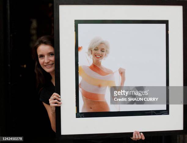 Lyon and Turnbull employee poses with one of the last photographs taken of Marilyn Monroe 'Marilyn Monroe in Stripe Scarf ' by Bert Stern during a...