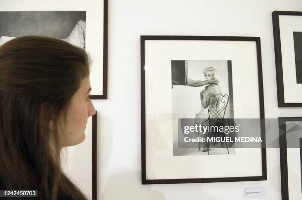 Woman poses looking at a photograph of late US actress Marilyn Monroe taken in the 1960s by late US photojournalist Eve Arnold on display during an...