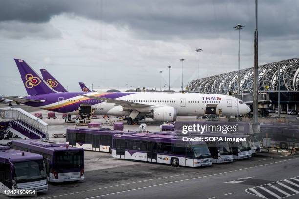 Thai Airways Airbus A330 is parked around transit buses outside a departure gate at Suvarnabhumi International Airport . International tourism...