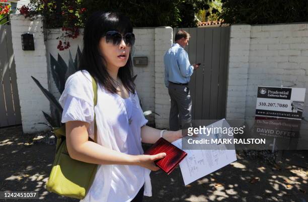 Potential buyers wait outside the former home of actress Marilyn Monroe which was the scene of her death in the Brentwood suburb of Los Angeles on...