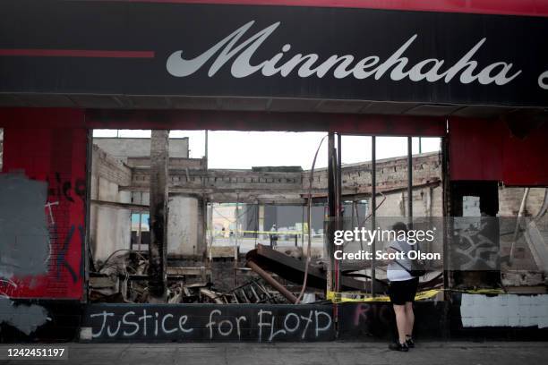 Woman looks at the charred wreckage of a building destroyed during last week's rioting which was sparked by the death of George Floyd on June 2, 2020...