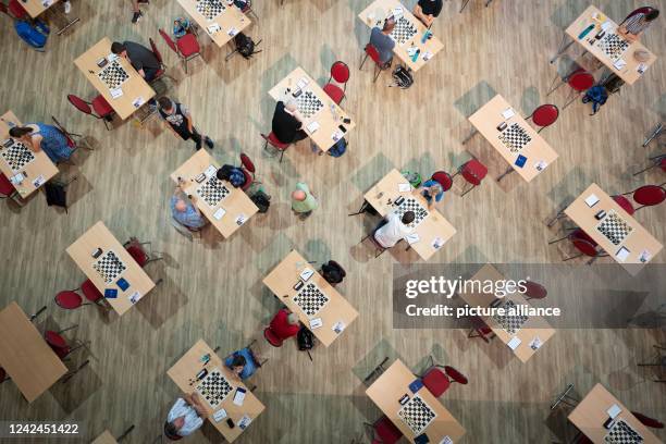 August 2022, Saxony, Bautzen: Participants of the international chess tournament "Bautzener Türme Open" sit in front of a chess board in the...