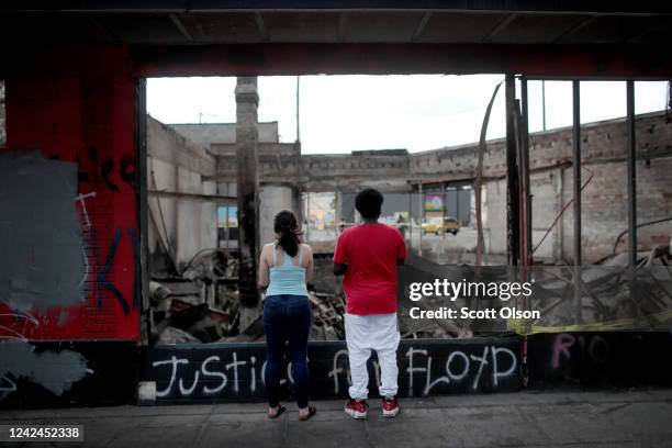 People look at the charred wreckage of a building destroyed during last week's rioting which was sparked by the death of George Floyd on June 2, 2020...