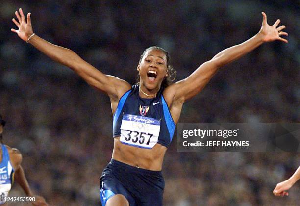 World sprint champion Marion Jones of the US crosses the finish line before a crowd in excess of 100,000 at Stadium Australia to win the final of the...