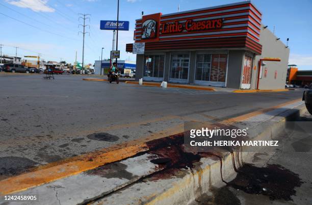 Blood stains are spread on the floor where four radio station workers were killed and two restaurant employees were wounded in Ciudad Juarez, state...