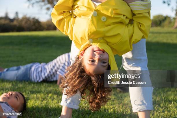 girl has fun being held upside down - new zealand yellow stock pictures, royalty-free photos & images