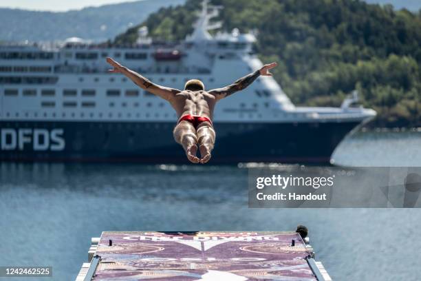 In this handout image provided by Red Bull, Neutral Athlete, Nikita Fedotov dives from the 27 metre platform at the Oslo Opera House during the first...