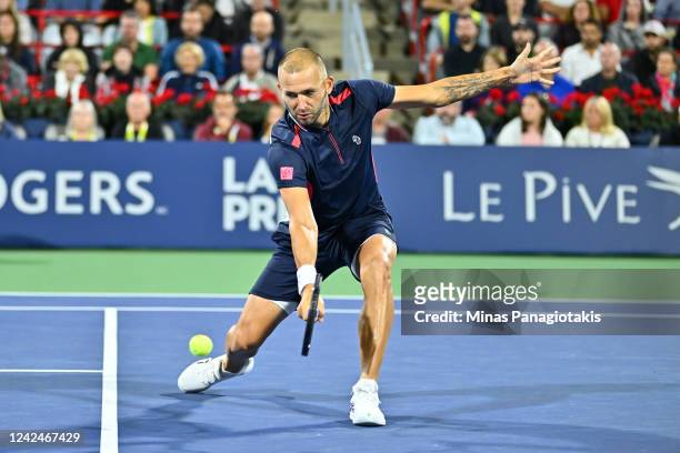 Daniel Evans of Great Britain hits a return against Tommy Paul of the United States during Day 7 of the National Bank Open at Stade IGA on August 12,...