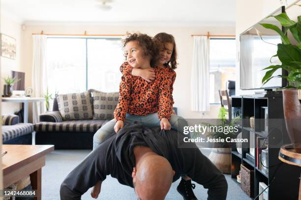 dad doing push-ups with twin daughters on his back - press ups stock pictures, royalty-free photos & images