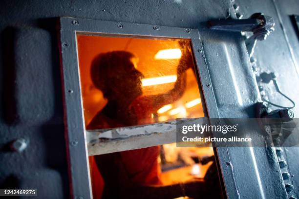 August 2022, Lower Saxony, Wilhelmshaven: A museum visitor moves behind a locked door in a so-called "Escape Room". The museum visitors, who are...