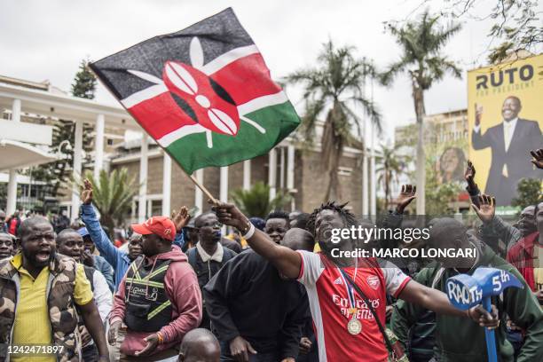 An Azimio la Umoja political coalition supporter waves a Kenyan national flag while holding a hammer with RAO 5th written on, outside the Kenya...