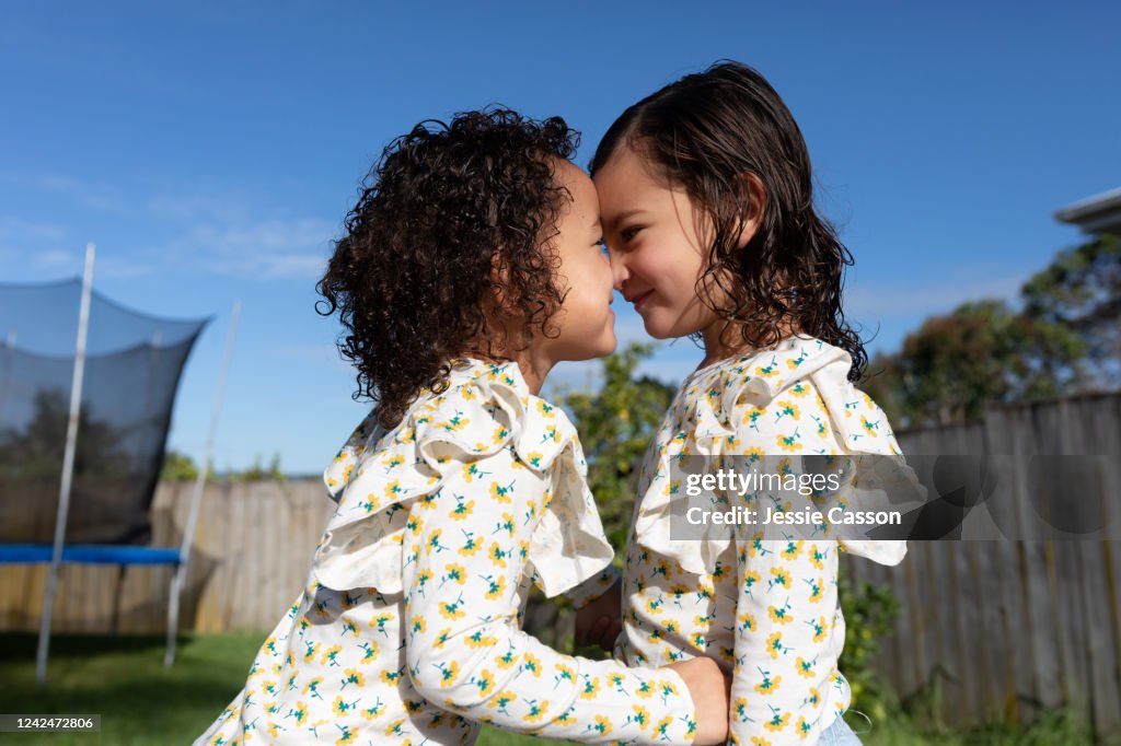 Twin sisters giving each other a hongi