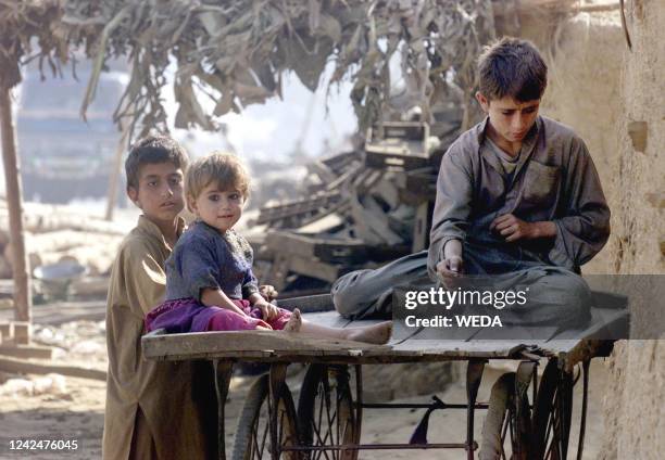 Afghan refugees play on an empty vetgetable cart on the outskirts of Islamabad, 20 November 2001. The United Nations High Commission have said that...