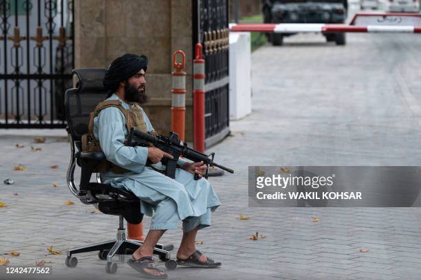 Taliban fighter guards a gate after a gathering attended by Afghanistan's Prime Minister Mohammad Hassan Akhund and Minister for Promotion of Virtue...
