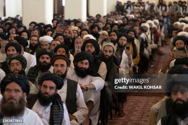 Taliban members listen to Afghanistan's Prime Minister Mohammad Hassan Akhund during a gathering at the former presidential palace in Kabul on August...