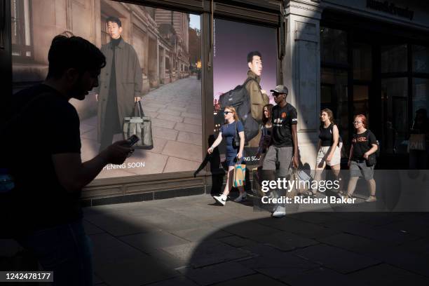 Shoppers walk past a menswear shop opening soon on Regent Street in the West End, on 12th August 2022, in London, England. After the Bank of England...