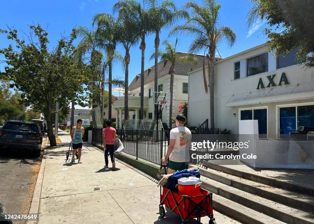 Los Angeles, California-Aug 12, 2022-Isaac Ignatius, right, president of Phi Kappa Tau, moves belongings from one fraternity house to a new house on...