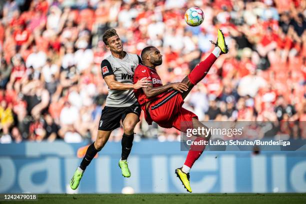 Florian Niederlechner of Augsburg and Jonathan Tah of Leverkusen in action during the Bundesliga match between Bayer 04 Leverkusen and FC Augsburg at...