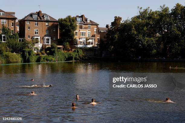 People have a swim on a pond in Hampstead Heath park to cool off from the heat, in London, on August 13, 2022. - The UK government on Friday...